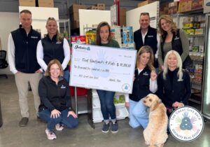 A group of people with an oversized check for Food Backpacks 4 Kids.