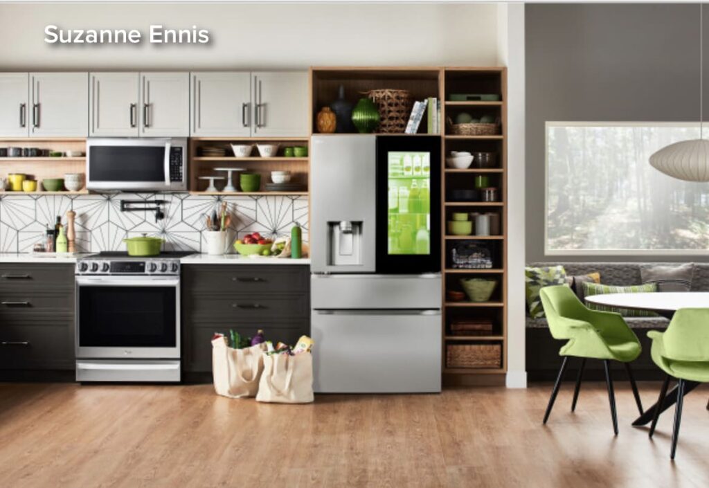 A kitchen with some groceries in bags next to the refrigerator.