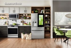 A kitchen with some groceries in bags next to the refrigerator.