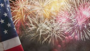 Fireworks with an American flag visible in the foreground.