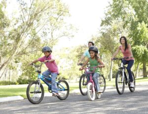 A family out cycling together on a sunny day.